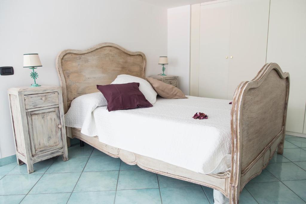 a bedroom with a large bed with white sheets and purple pillows at San Gregorio Luxury Apartments in Naples