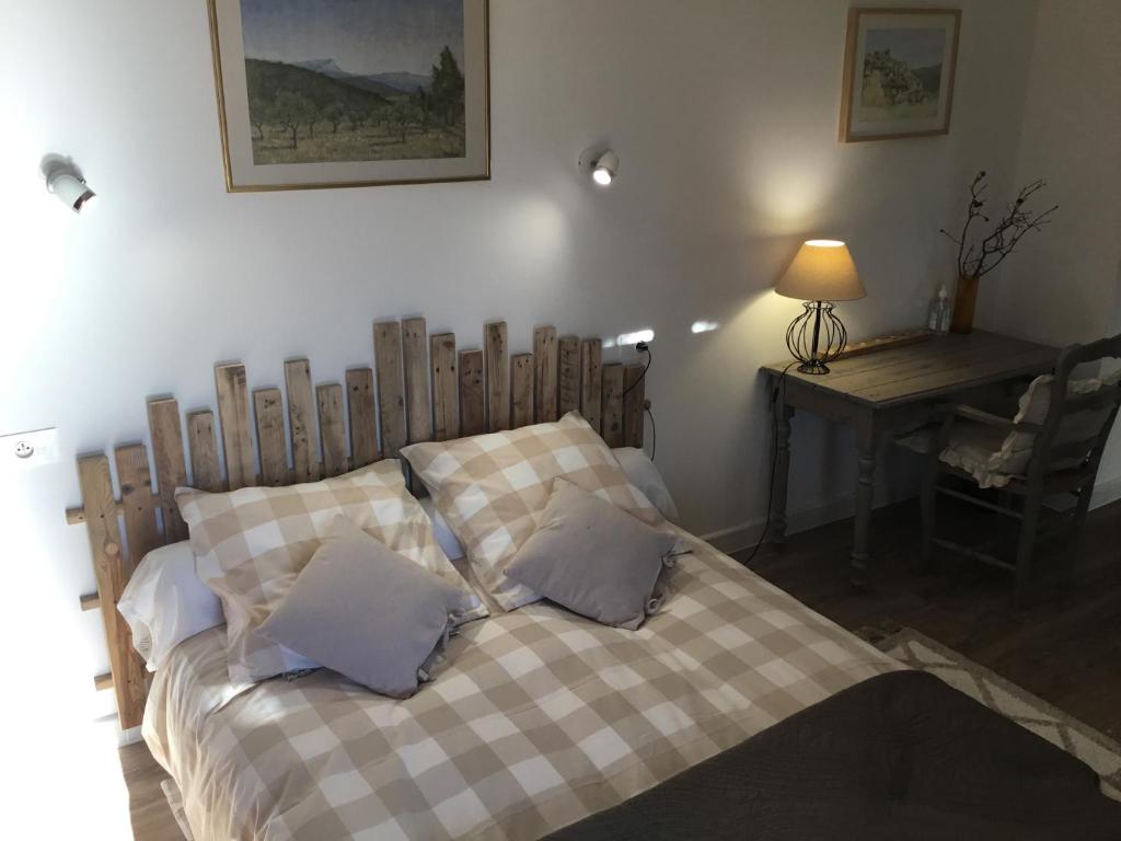 a bedroom with a bed with a table and a desk at Petit cocon dans le Luberon in Lauris