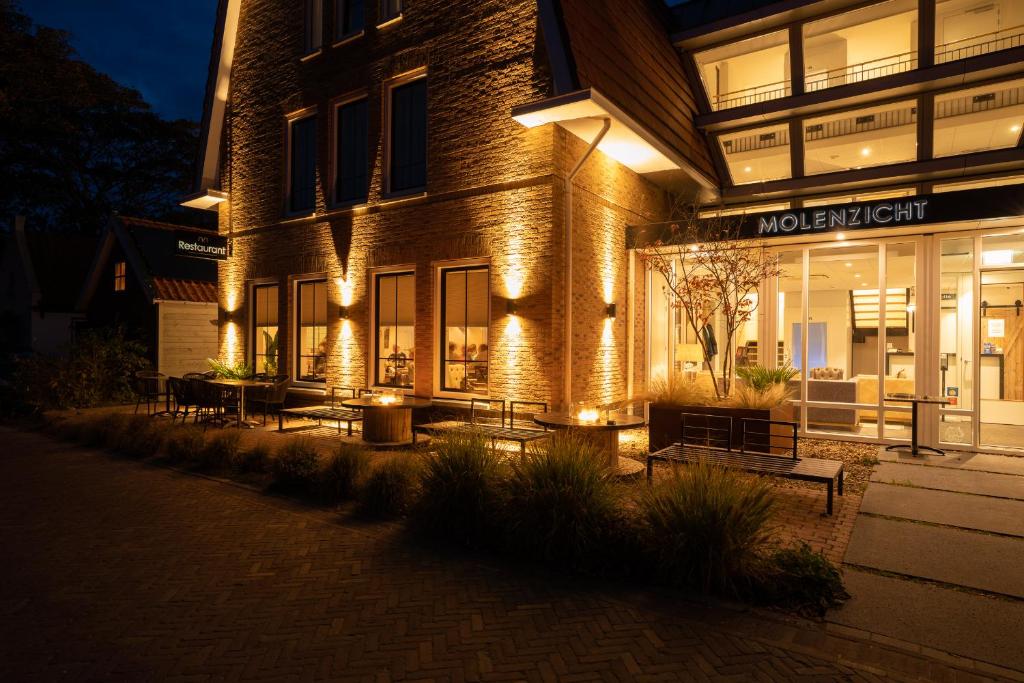 un bâtiment avec des lumières sur son côté la nuit dans l'établissement Hotel Restaurant "Molenzicht", à Nes