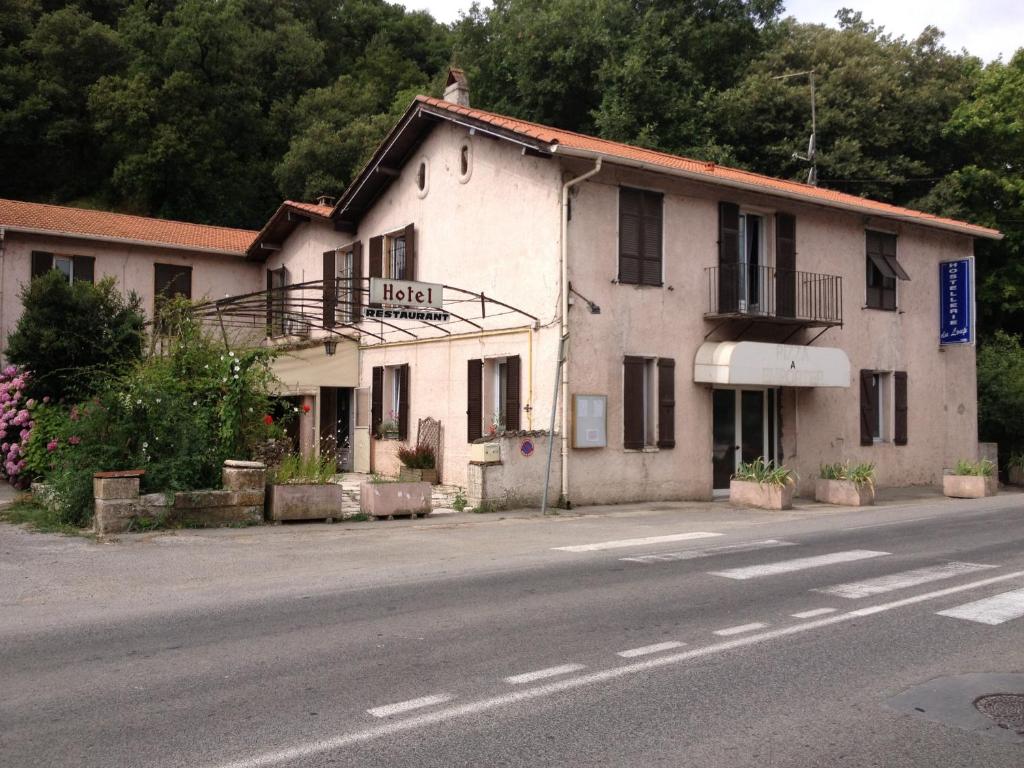 un bâtiment situé sur le côté d'une rue dans l'établissement Hostellerie du loup, à Villeneuve-Loubet