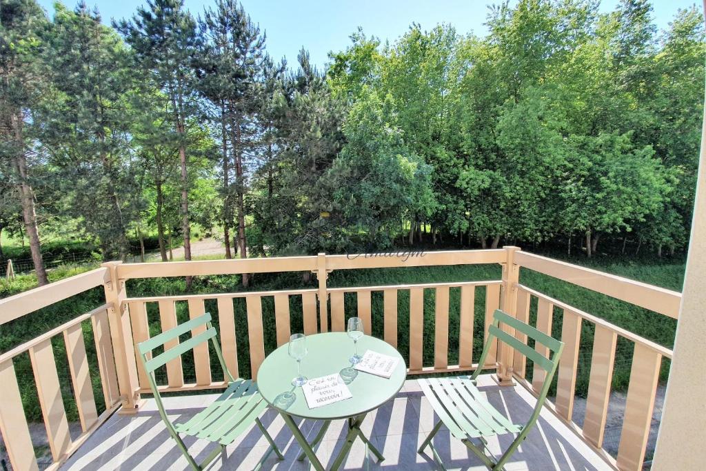una mesa y sillas en un balcón con árboles en SV 8 -Les Ecureuils bel appartement dans une résidence calme et sécurisée, en Saint-Valery-sur-Somme