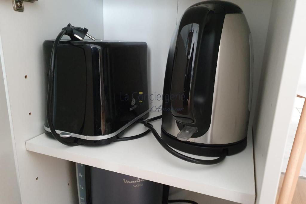 two black appliances are sitting on a shelf at A 2 PAS du PORT in Saint-Valéry-sur-Somme