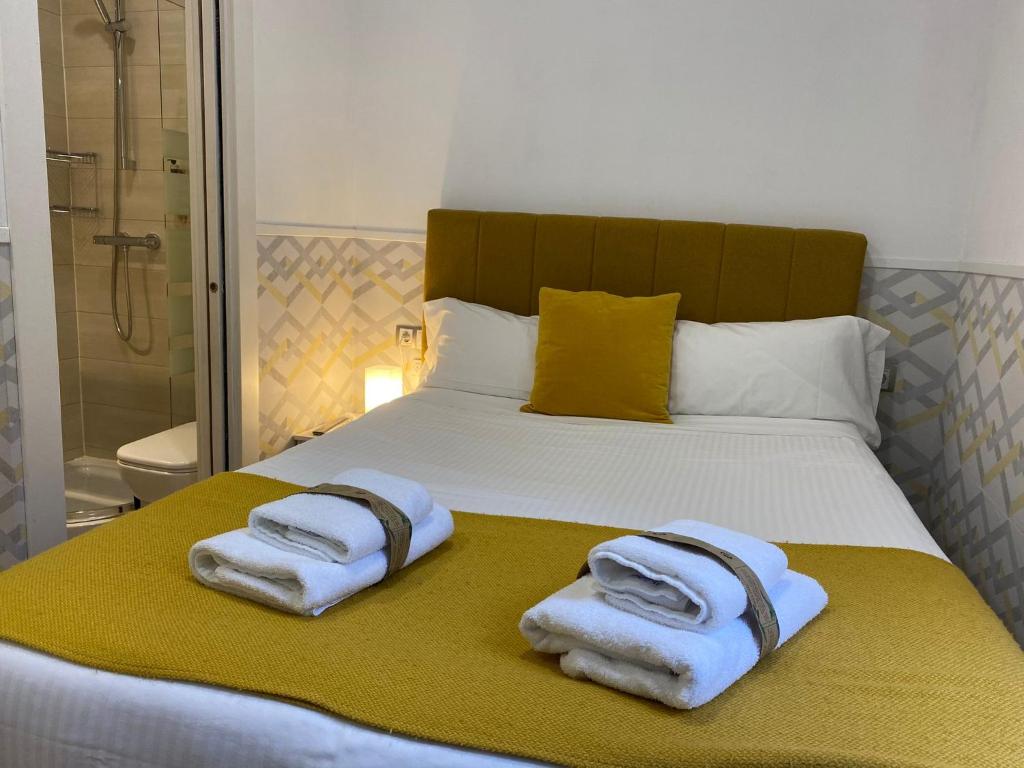 Una cama con toallas encima. en INSIDEHOME Valladolid Centro -Hab con baño privado en el centro y OPCION DE PARKING-, en Valladolid