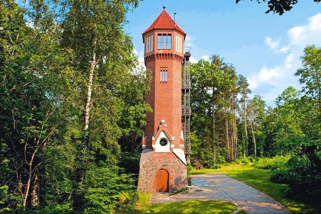 einen hohen Backsteinturm inmitten eines Waldes in der Unterkunft Water tower, Kuchelmiss in Kuchelmiß