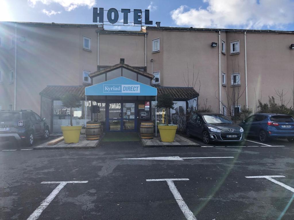 un hôtel avec des voitures garées dans un parking dans l'établissement Kyriad Direct Macon Sud, à Crêches-sur-Saône