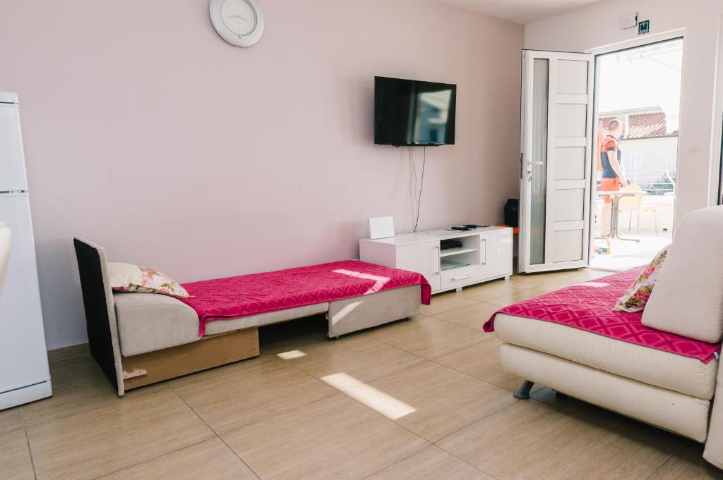 Televízia a/alebo spoločenská miestnosť v ubytovaní Apartmani Mila Brela