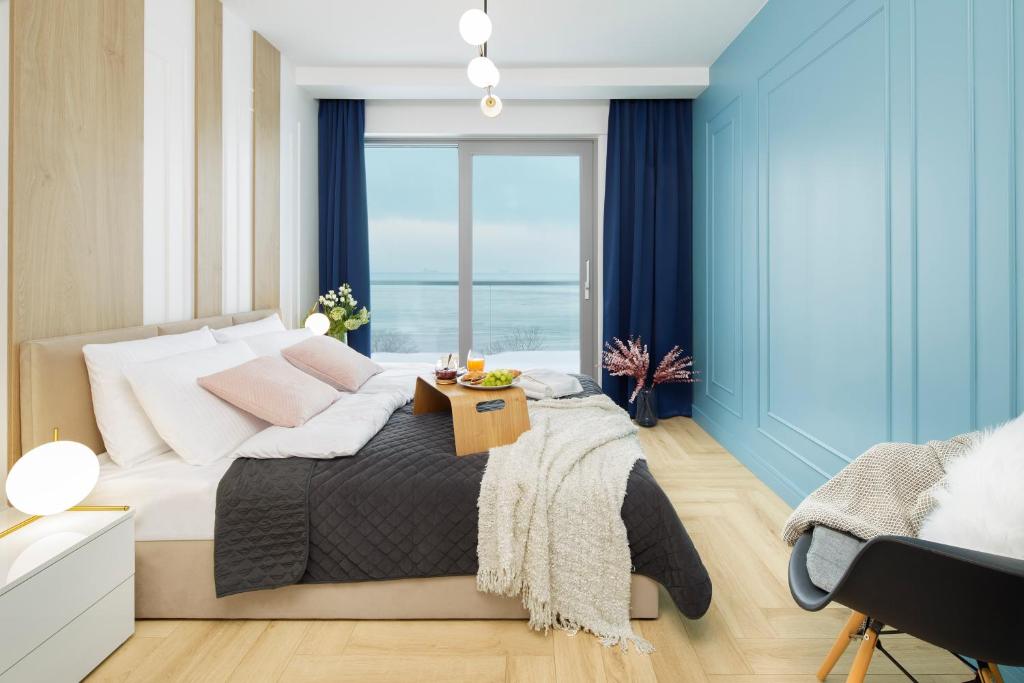 een slaapkamer met een bed en uitzicht op de oceaan bij Balticus Apartamenty Deluxe Promenada Gwiazd 14 in Międzyzdroje