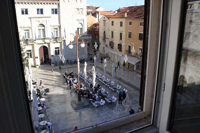 una vista desde una ventana de una calle con gente sentada en las mesas en Apartment Moka Central Square en Zadar