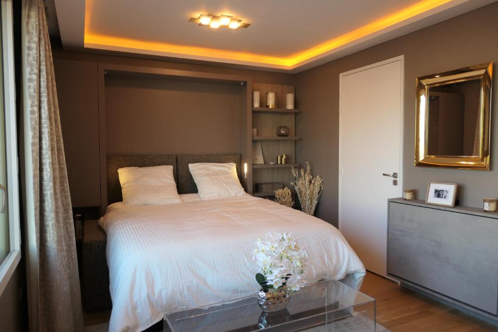 a bedroom with a bed with white sheets and flowers on it at Luxury Studio Daumesnil Wifi & Netflix in Paris