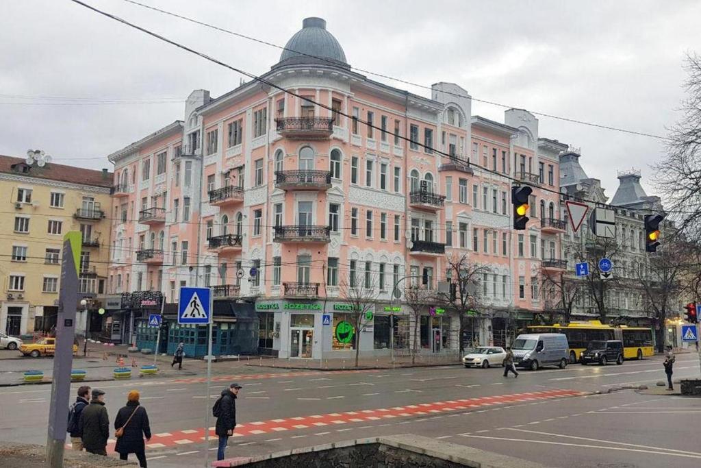 un grand bâtiment rose au coin d'une rue dans l'établissement Maison Blanche Kyiv city center, à Kiev