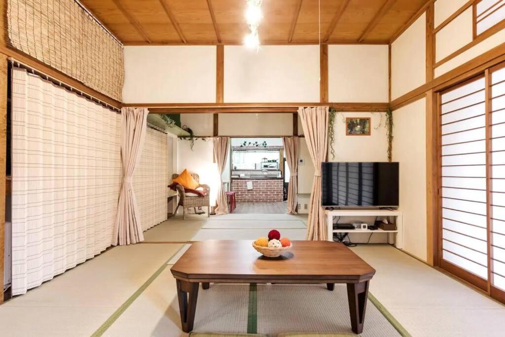 a living room with a table and a television at Forest Villa Hakone in Hakone