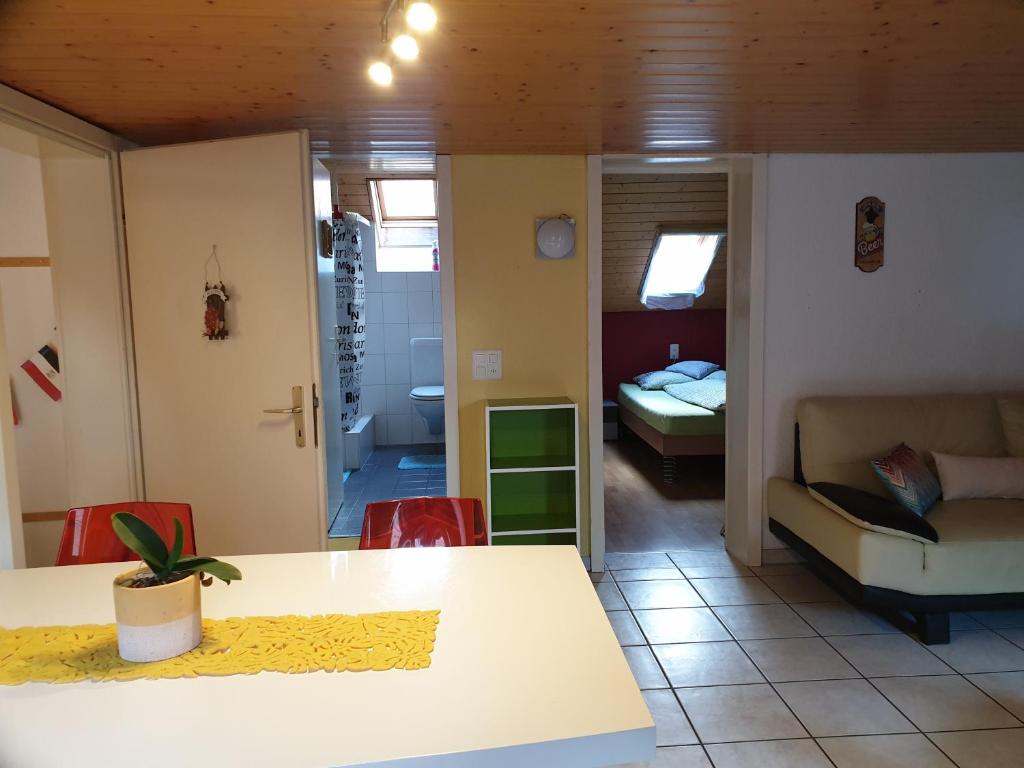 ein Wohnzimmer mit einem Tisch und einem Sofa sowie ein Schlafzimmer in der Unterkunft Apartment Dorfstrasse 16 in Leuzigen
