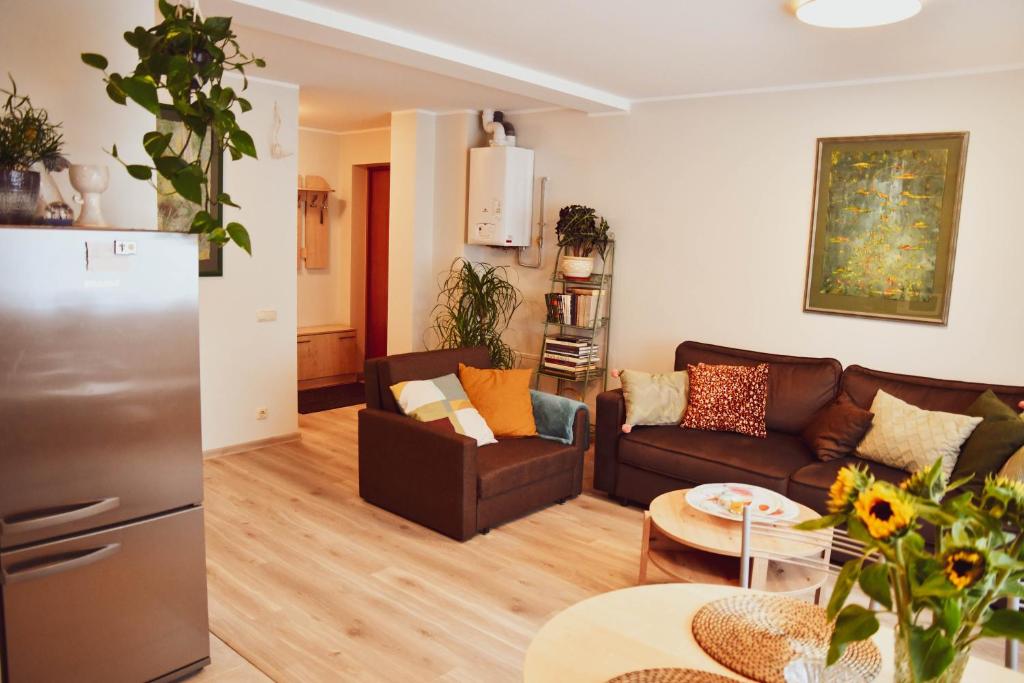ein Wohnzimmer mit einem Sofa und einem Tisch in der Unterkunft Central Park Apartment Birštonas in Birštonas