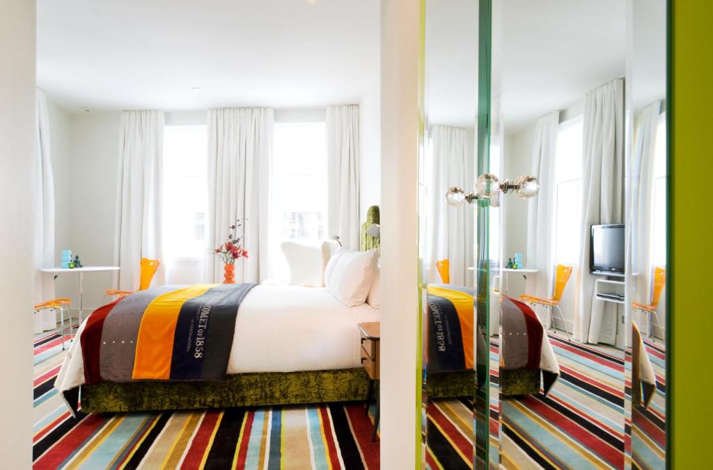 a hotel room with a bed and a tv at Hotel DeBrett in Auckland