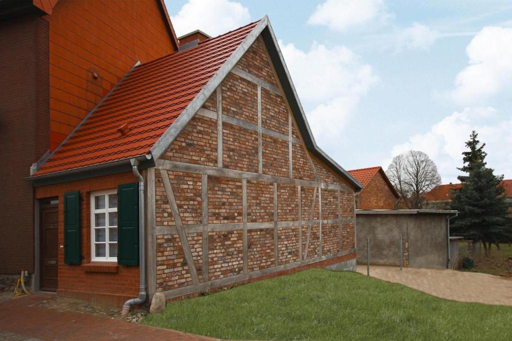 a brick barn with a red roof at Holiday home in Neukalen in Neukalen