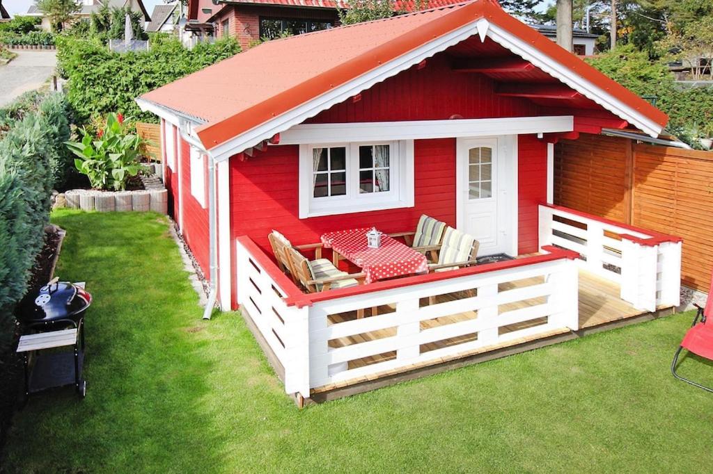 une maison pour chiens rouges et blancs sur une pelouse dans l'établissement Holiday home, Plau am See, à Plau am See