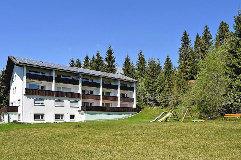 ein großes Gebäude mit einem Spielplatz auf dem Feld in der Unterkunft Apartment in Haidm hle with balcony or terrace in Haidmühle