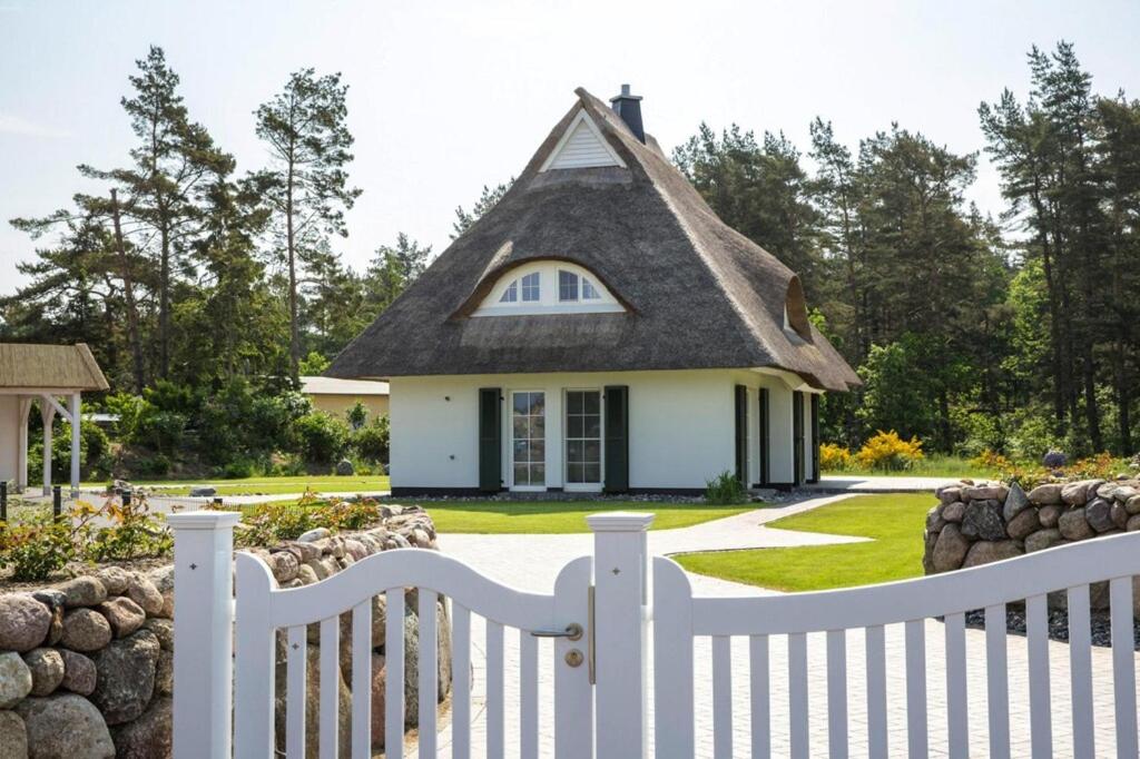 a white picket fence in front of a house at Holiday house, Fuhlendorf in Fuhlendorf