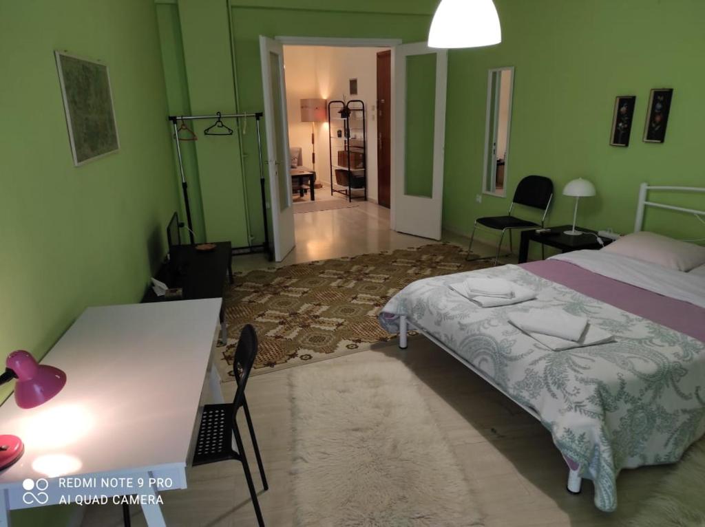 科莫蒂尼的住宿－Square，一间卧室配有一张床和一张书桌,拥有绿色的墙壁