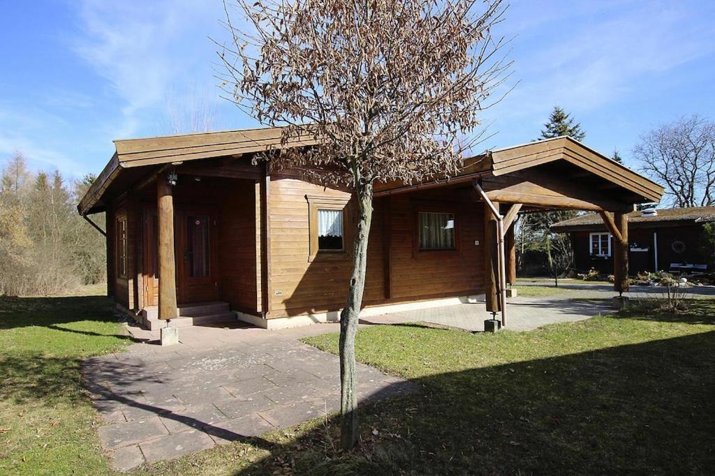 a small wooden house with a tree in front of it at Blockhouse, Hasselfelde in Hasselfelde