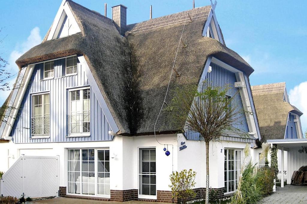 an old white house with a thatched roof at Semi-detached house, Zingst in Zingst