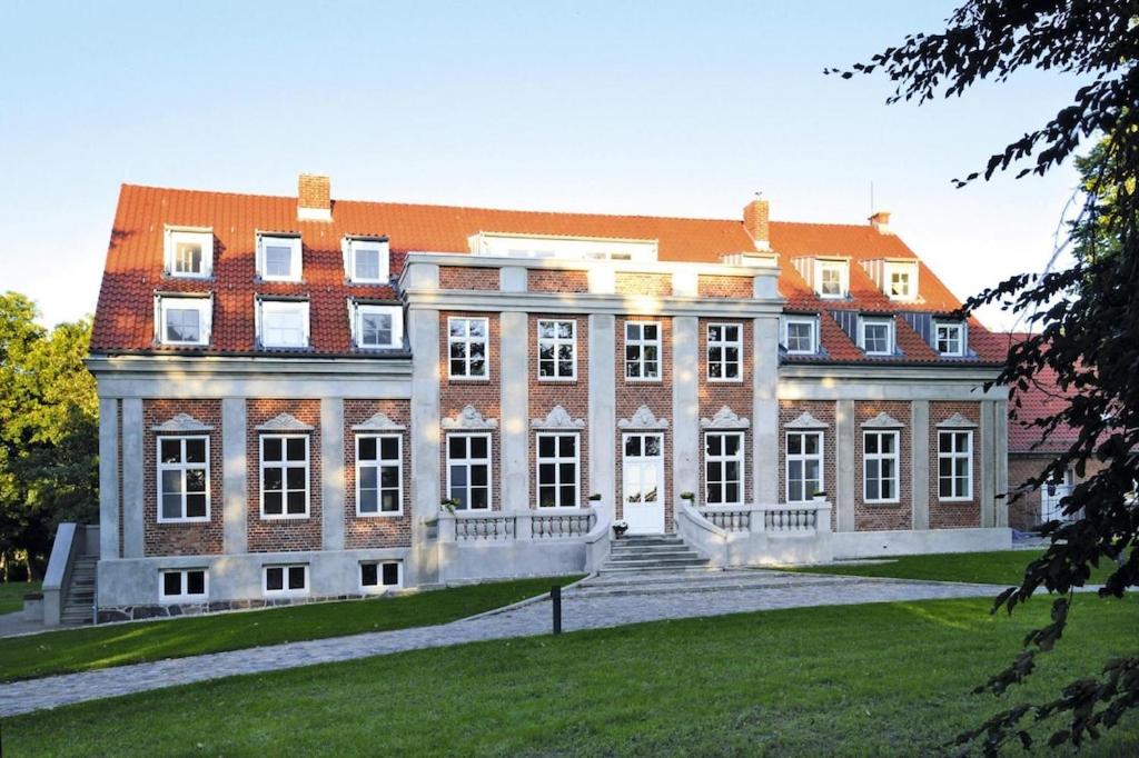 a large brick building with a staircase in front of it at Gutshaus Zicker in Garz in Garz-Rügen