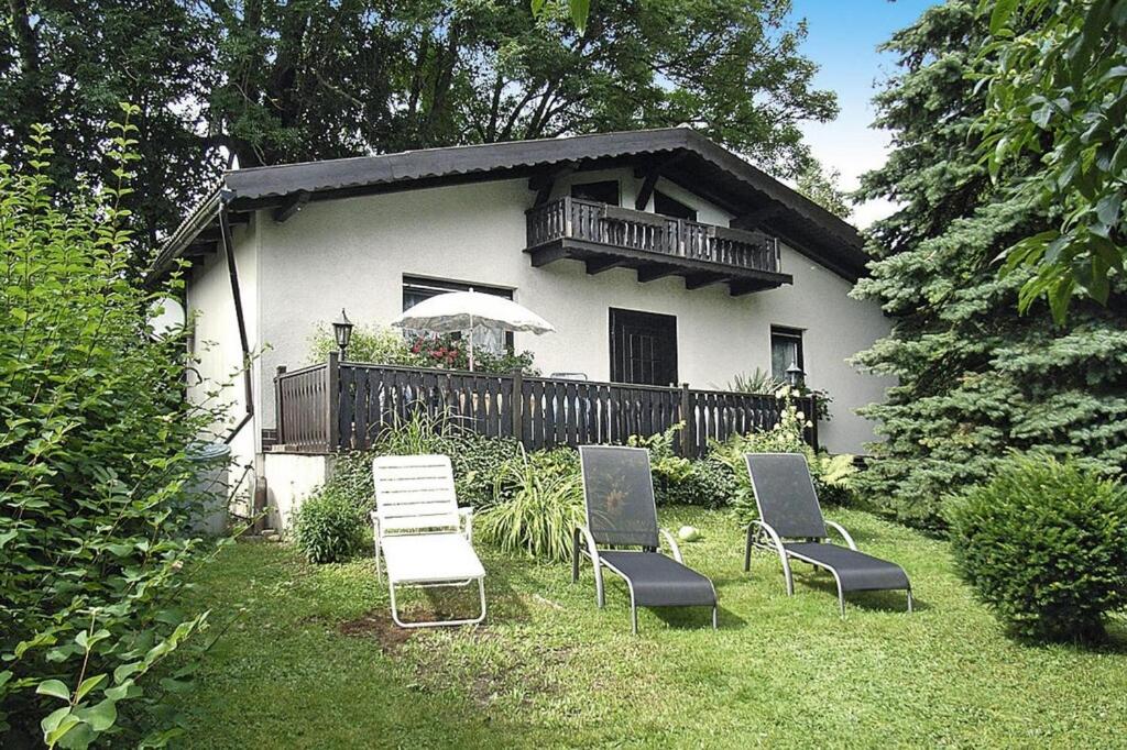 um grupo de cadeiras sentadas na relva em frente a uma casa em Cottage, Jagdhof em Judenbach