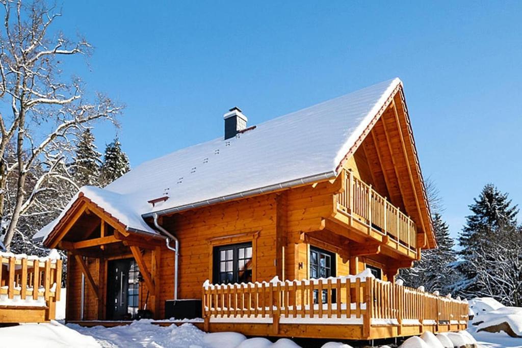 ein Blockhaus mit einem schneebedeckten Dach in der Unterkunft Cottage, Schierke in Schierke