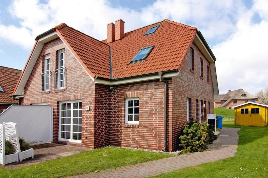 ein Backsteinhaus mit rotem Dach in der Unterkunft Ferienhaus Marlina Glückstreffer, Büsum in Büsum