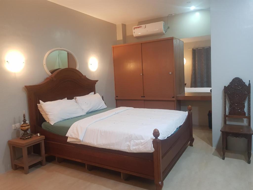 a bedroom with a bed with a mirror on the wall at B&S pension house in Dipolog