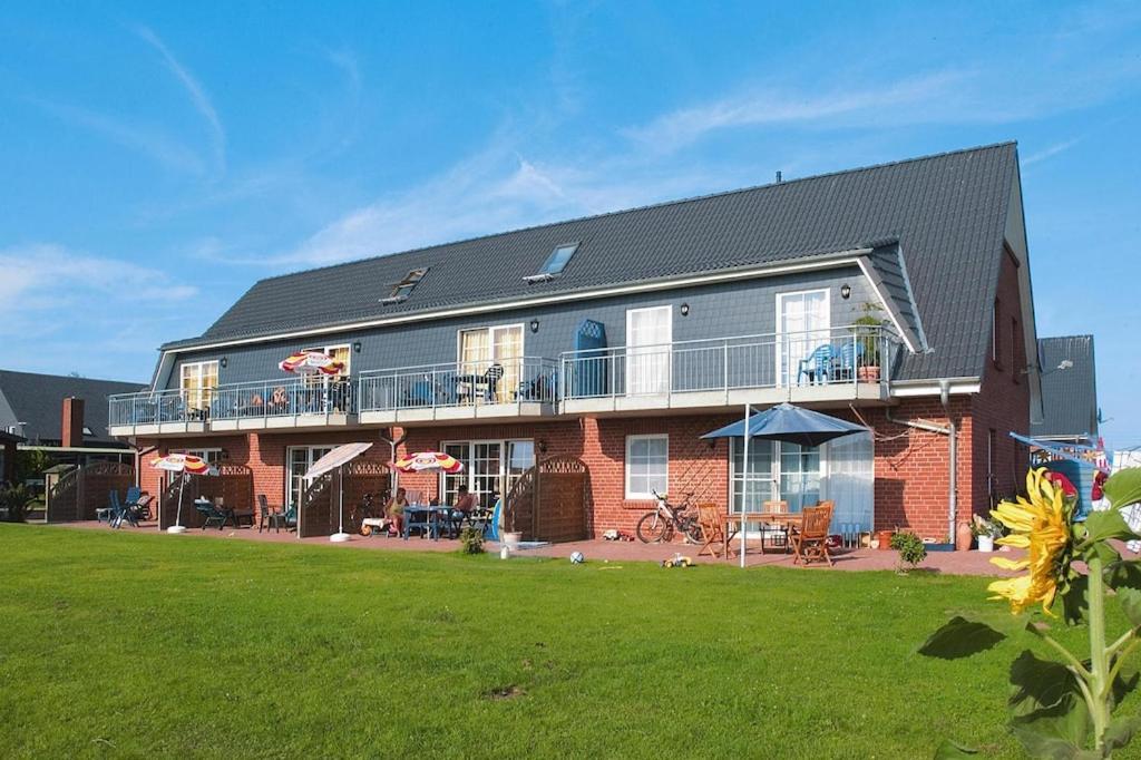 a large brick house with a balcony and a yard at Holiday complex Schuldt, Behrensdorf in Behrensdorf