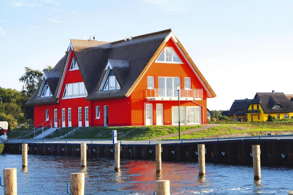 a large red house sitting on top of a body of water at Ferienwohnung Seemöwe im Fährhaus in Vieregge in Vieregge
