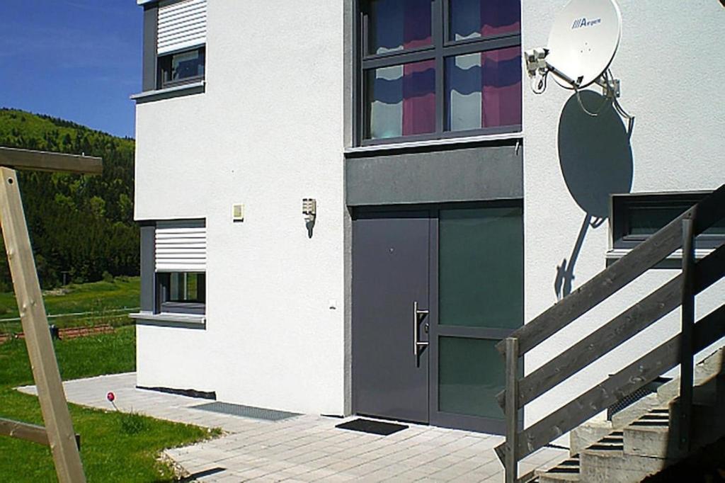 biały budynek z drzwiami i schodami w obiekcie Apartment, Messstetten w mieście Meßstetten