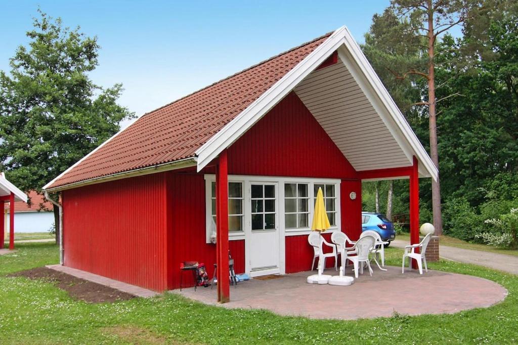 a red shed with a table and chairs in it at Holiday home in Markgrafenheide with paid sauna in Markgrafenheide