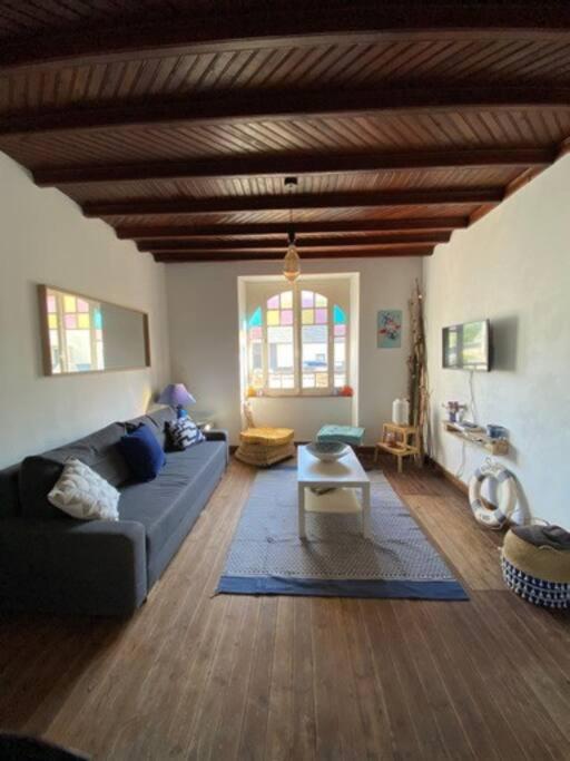 a living room with a couch and a table at LES CLAPOTIS RUE DU PHARE QUIBERON in Quiberon