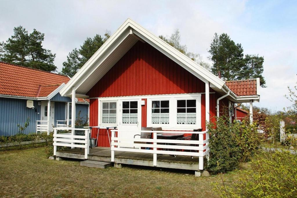a red and white house with a white fence at Holiday house at the Useriner See, Userin in Userin