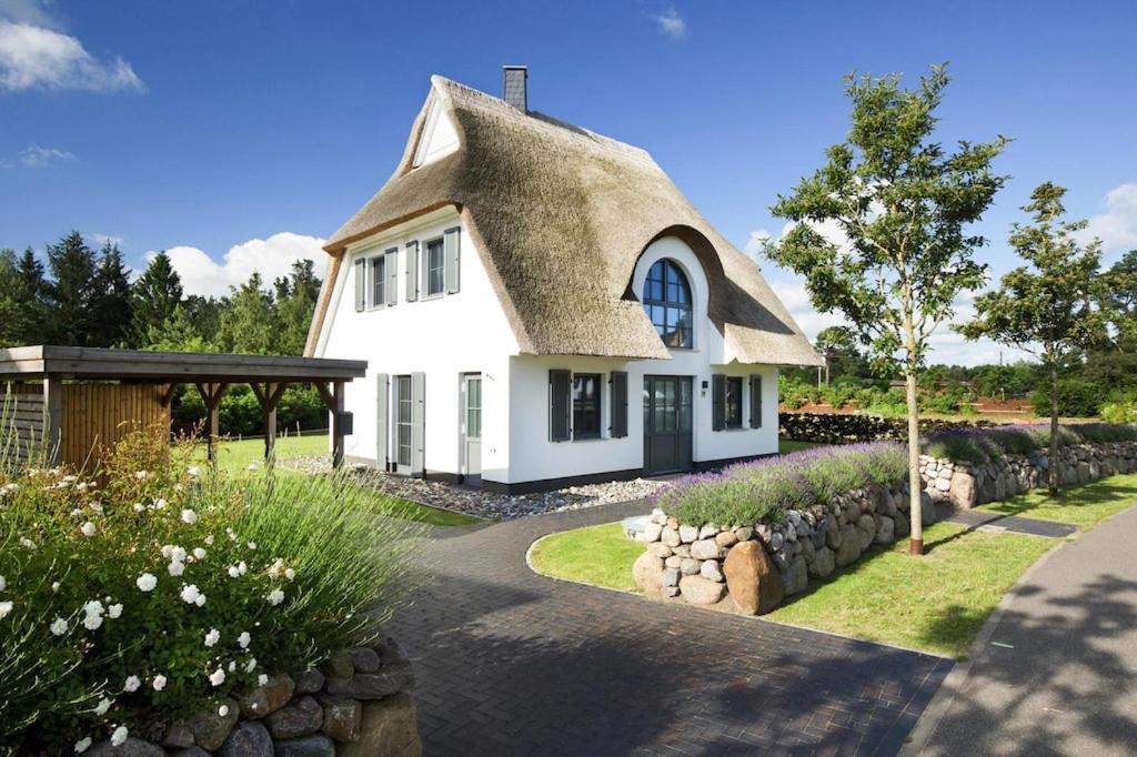 una casa bianca con tetto di paglia di Holiday house, Fuhlendorf a Fuhlendorf