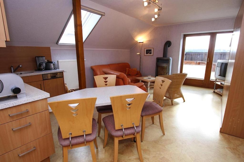 eine Küche und ein Wohnzimmer mit einem Tisch und Stühlen in der Unterkunft Holiday complex Landlust M hlental in Oberwürschnitz
