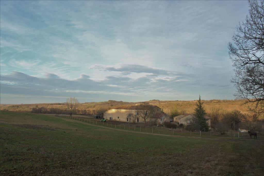 a field with a fence and a barn in the distance at Domaine de la Couderquié in Lautrec