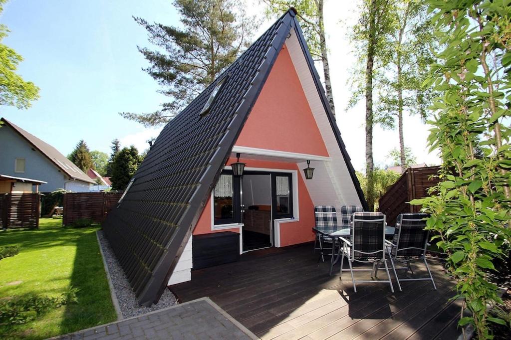 a small house with a black roof with a deck at Holiday home Stork's Nest 2, Falkensee in Falkensee