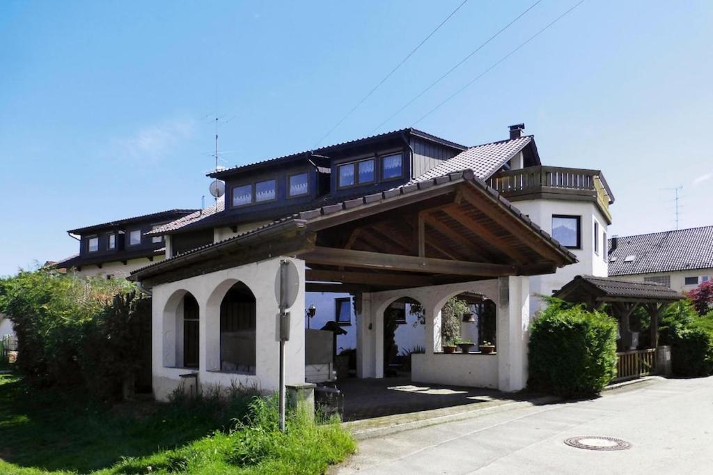 ein großes weißes Haus mit Holzdach in der Unterkunft Apartment, Oberdorf near Langenargen in Oberdorf
