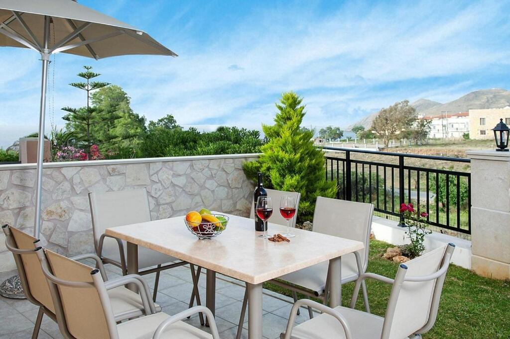 a table and chairs on a patio with an umbrella at Cottage, Panormo in Panormos Rethymno