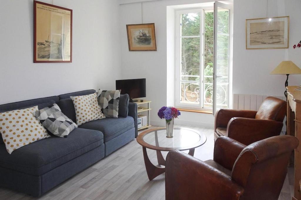 sala de estar con sofá azul y mesa en Apartment Beg Meil, en Fouesnant