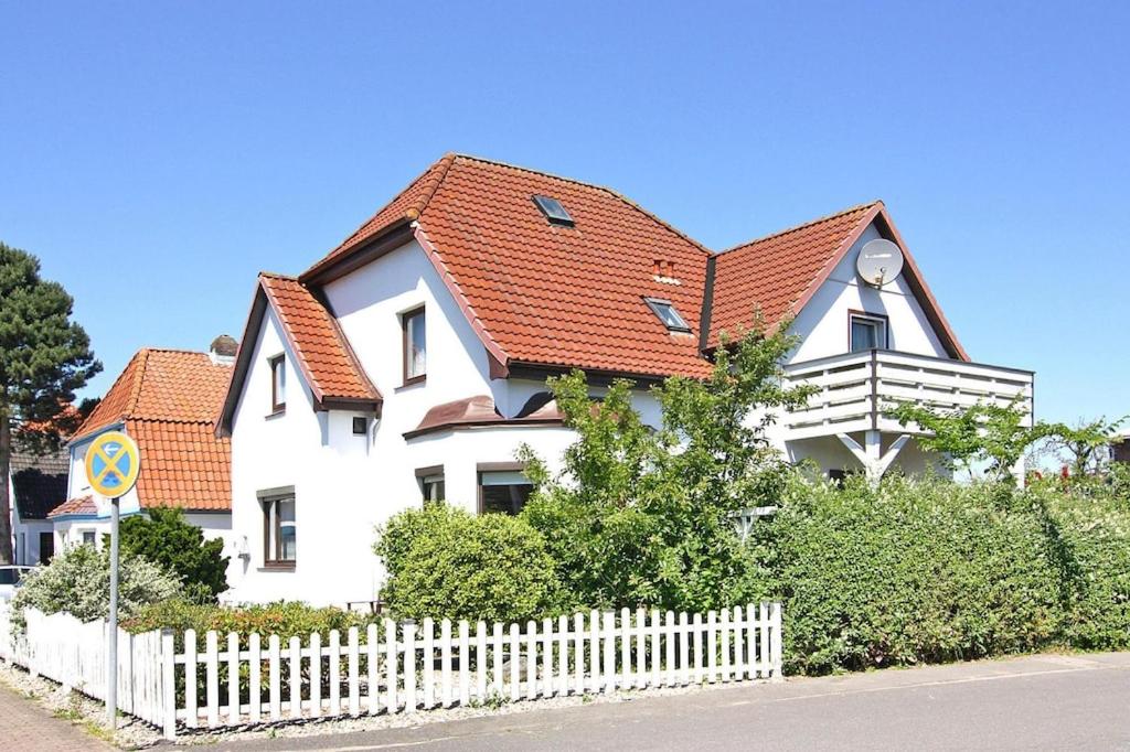 ein weißes Haus mit rotem Dach und einem weißen Zaun in der Unterkunft A holiday home in Büsum with a barbecue in Büsum