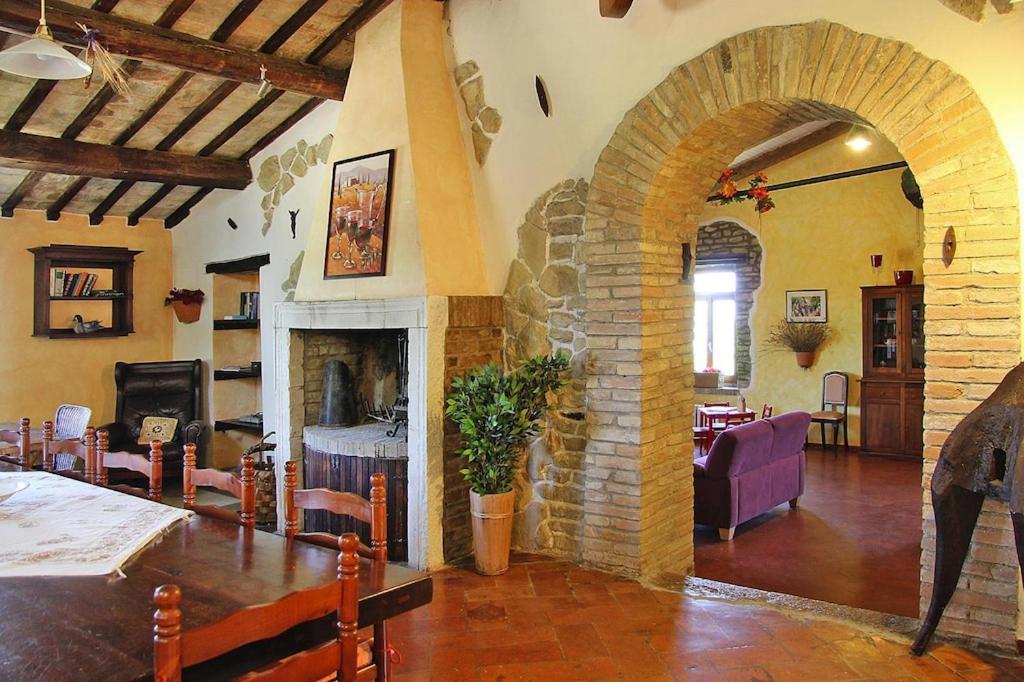 a living room with a stone fireplace and a dining room at Villa Ca Piero Urbino in Urbino
