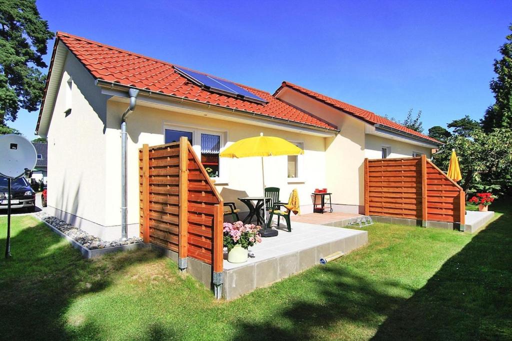 uma casa com um pátio com uma mesa e um guarda-chuva em Semi-detached house, Lubmin em Lubmin