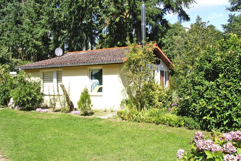 a small white house in a yard at Ferienhaus Vieting direkt am Eldeufer in Parchim in Parchim