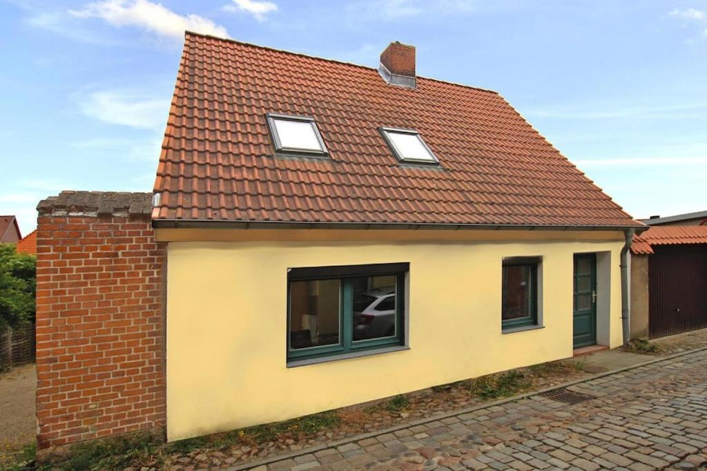 een klein geel huis met een rood dak bij Cottage, Plau am See in Plau am See