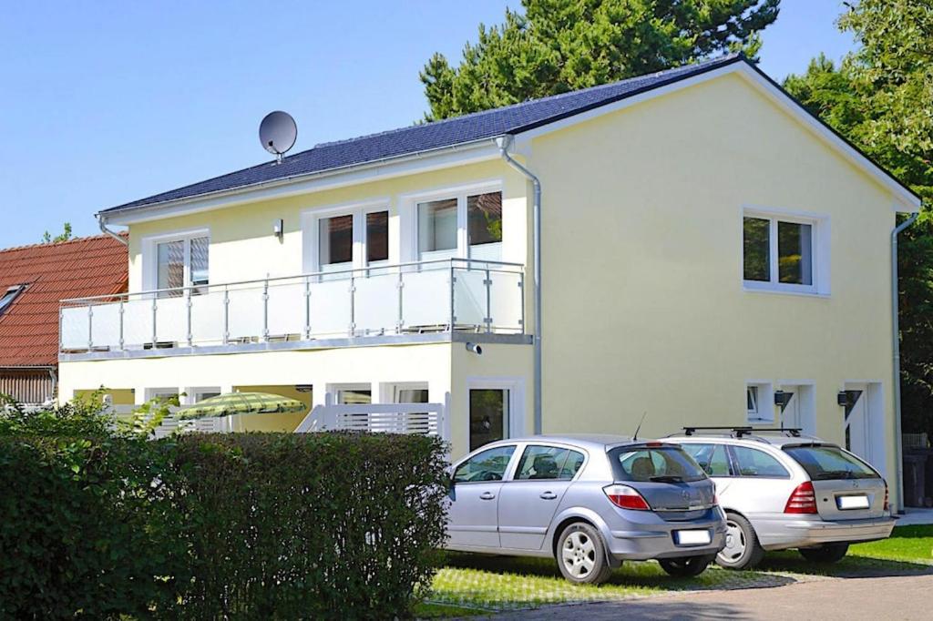 zwei Autos, die vor einem weißen Haus geparkt sind in der Unterkunft Studio apartment Wyk auf Föhr - DNS10103j-S in Wyk auf Föhr