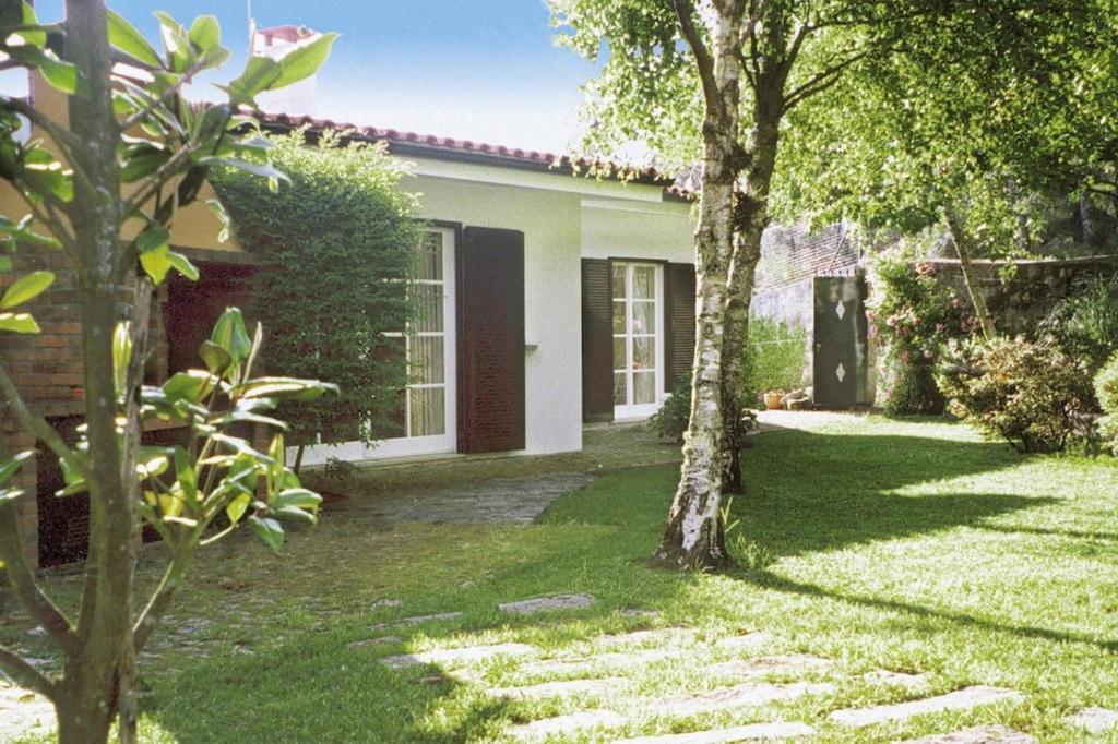 a house with a green yard with a tree at Holiday Home bei Viana do Castelo Carreco - PON03016-F in Carreço